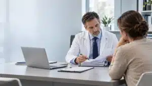 Complicación quirúrgica o mala práctica médica en Colombia: médico perito revisando un caso con una paciente